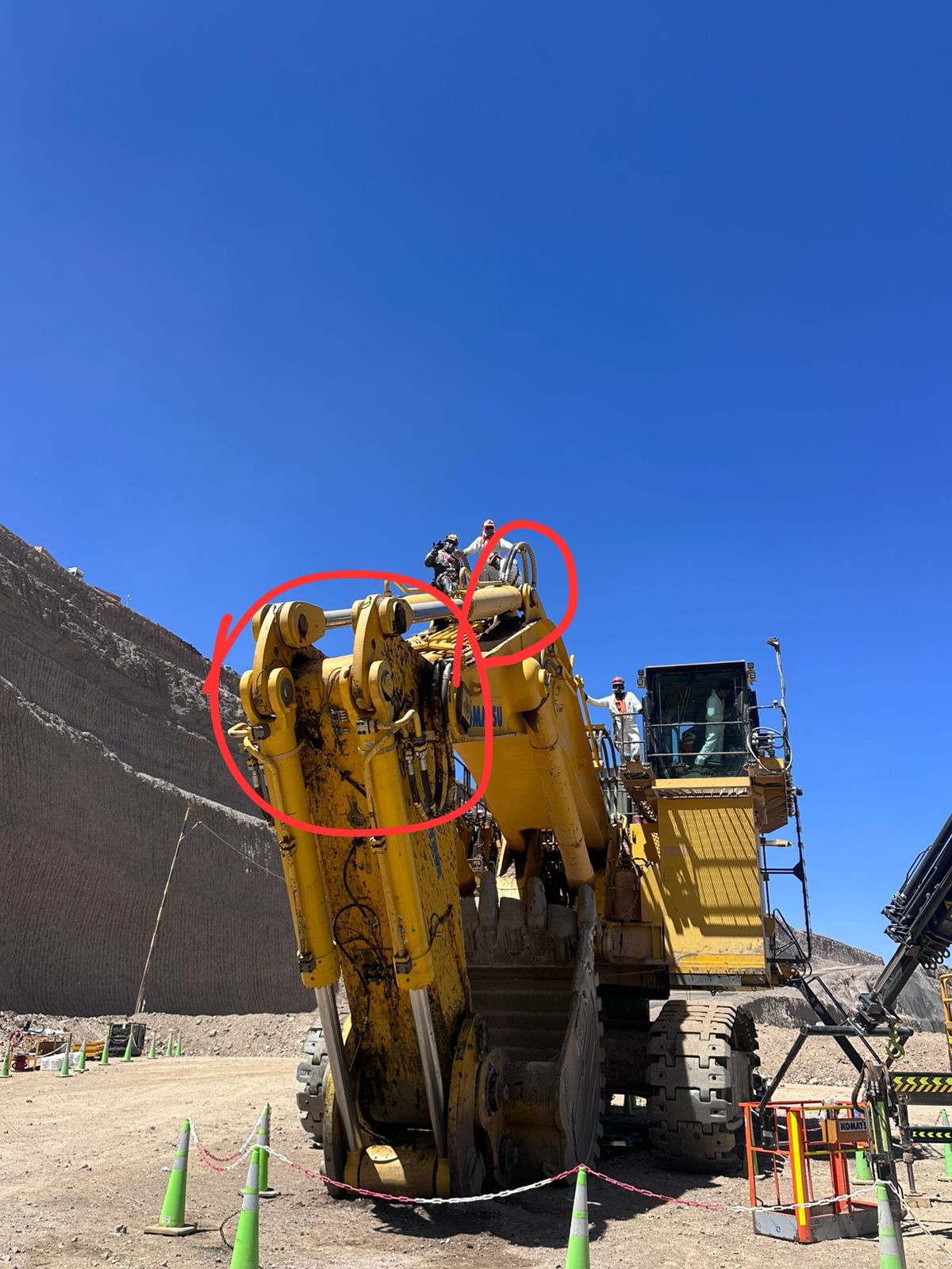 Operarios sobre stick de pala hidraulica Komatsu inspeccion manual en faena